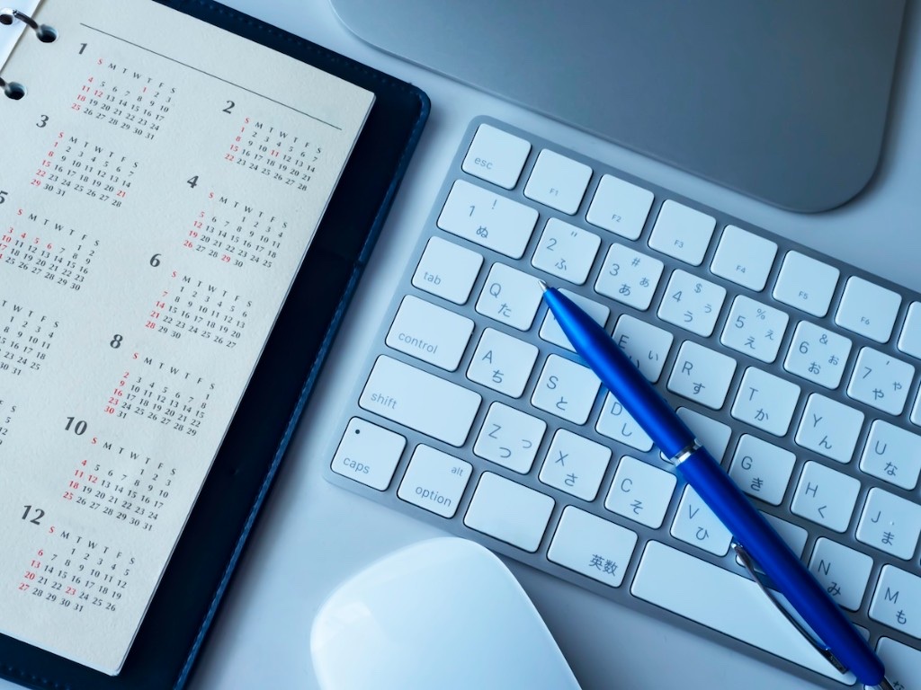 イベント用オリジナルグッズの準備を、カレンダーや手帳で逆算してスケジュールしている様子。本番の2〜3か月前から動き始めるのがおすすめ。